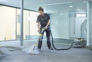 a male cleaning contractor steam cleans an office carpet in a empty office in between tenants.
